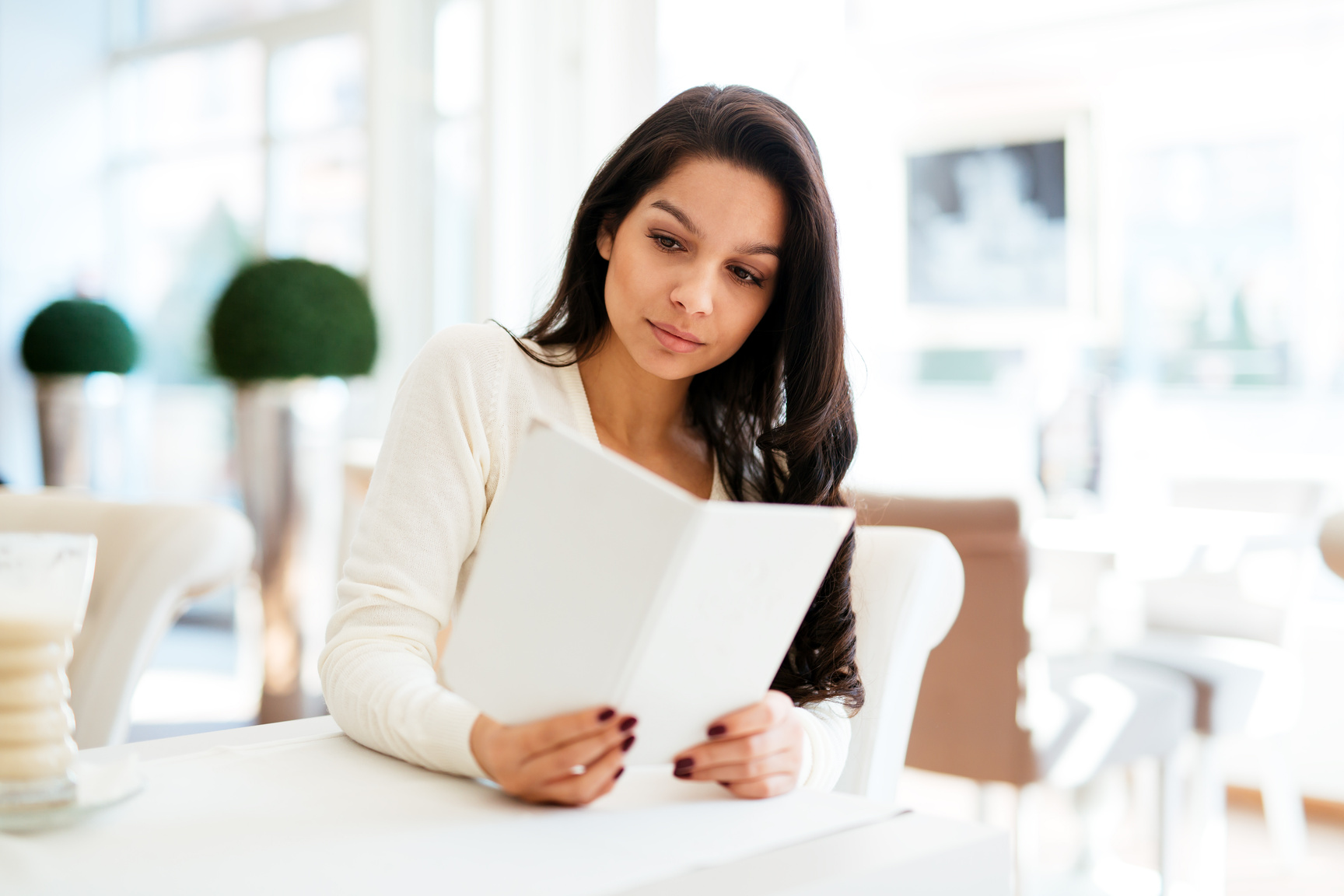 Beautiful woman looking at menu in restaurant